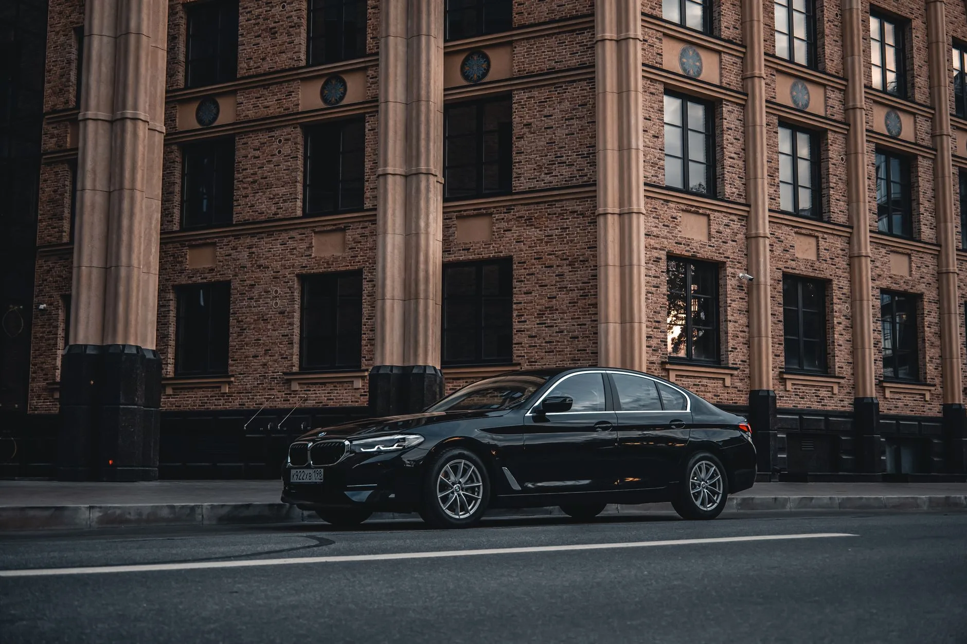 A luxury sedan parked on a Barcelona street at dusk, ready for rental.