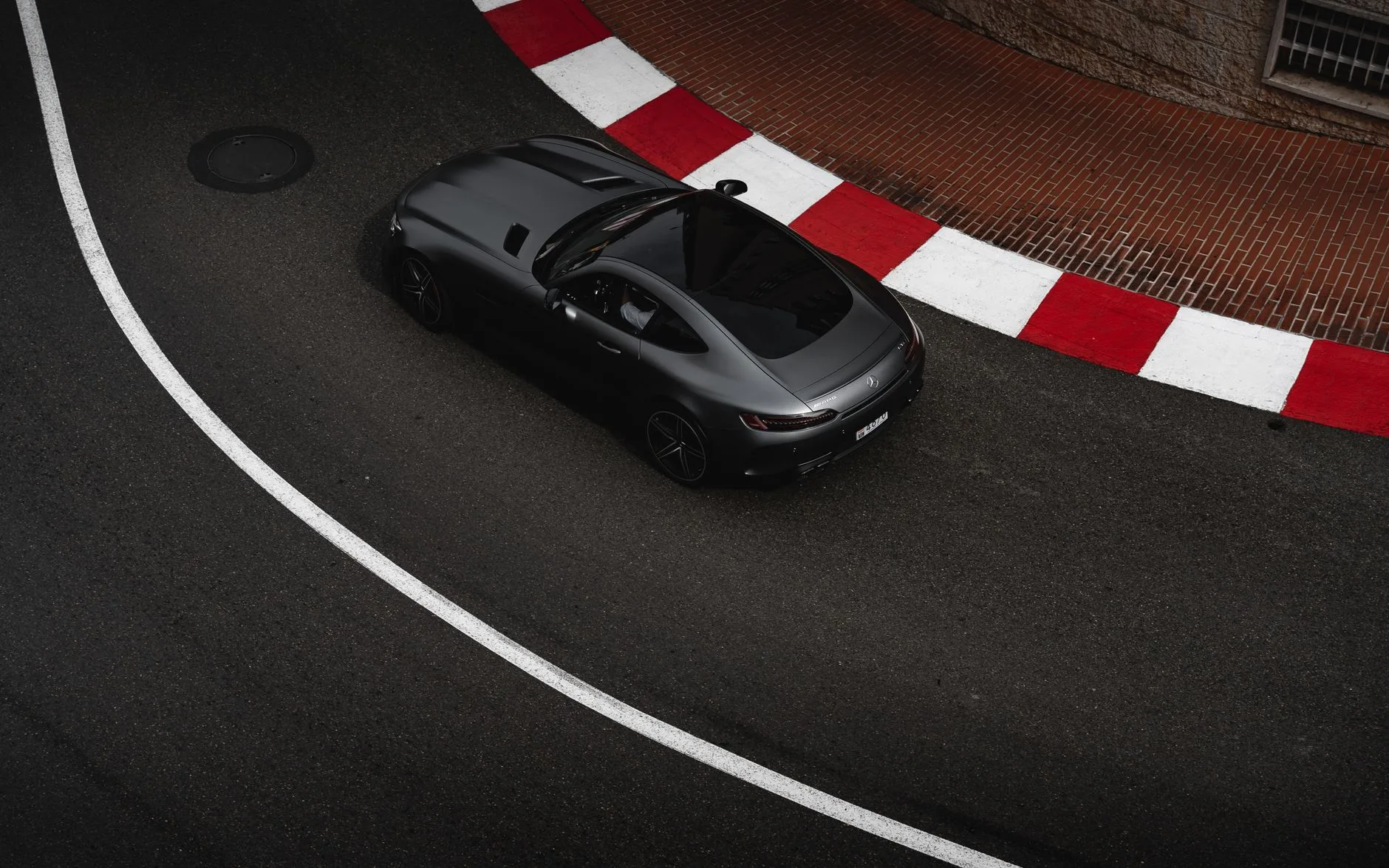 A sports car moving along a coastal road near Barcelona.